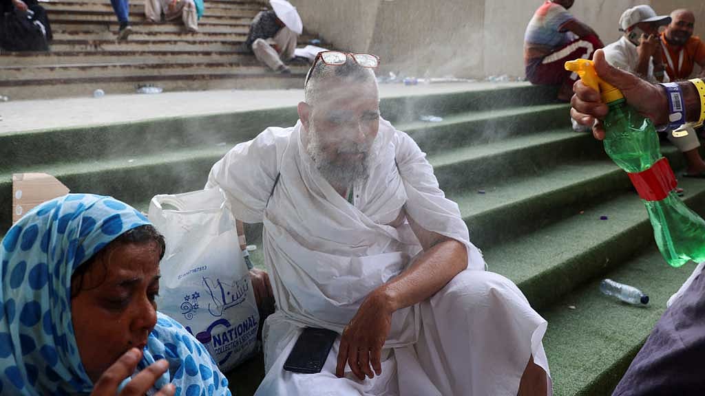 Muslim pilgrims are sprayed with water during extremely hot weather, on the first day of the Satan stoning ritual, during the annual haj pilgrimage, in Mina, Saudi Arabia, June 16, 2024. REUTERS/Saleh Salem