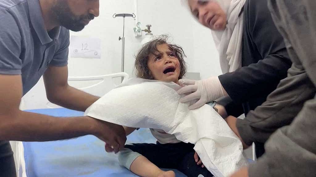 A Palestinian child, wounded in an Israeli strike on an area designated for displaced people, is assisted at a hospital as the war in Gaza continues, in Rafah in the southern Gaza Strip, May 26, 2024, in this screen grab from a video obtained by Reuters. VIDEO OBTAINED BY REUTERS via REUTERS TV