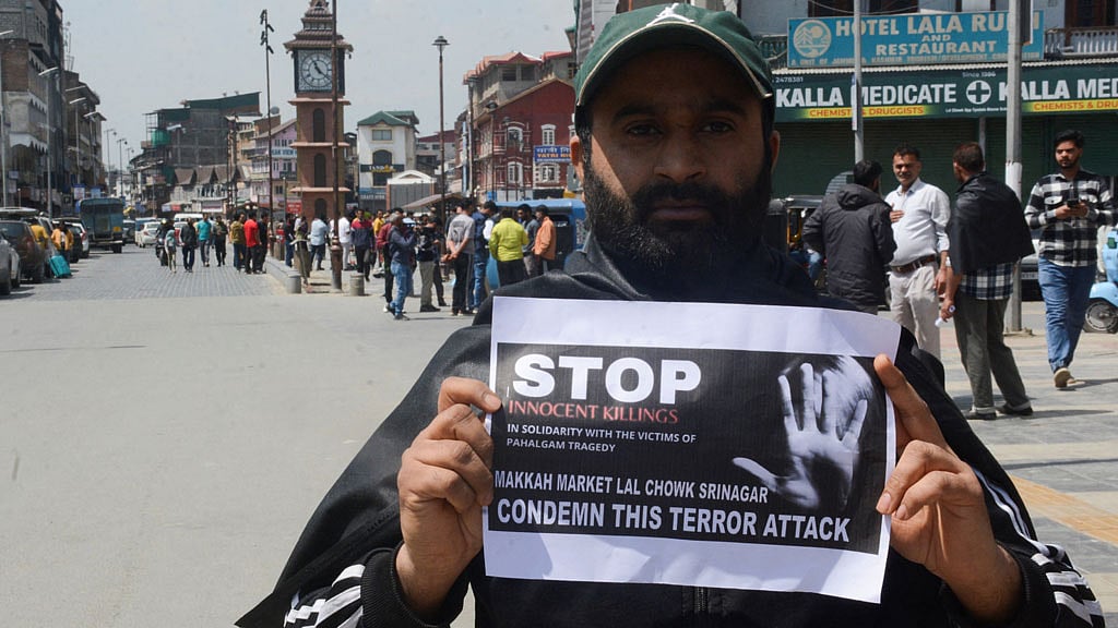 Kashmiri trader holds a sign during a protest against the attack on tourists, following a suspected militant attack in south Kashmir's scenic Pahalgam, in Srinagar, Apr 23, 2025. REUTERS