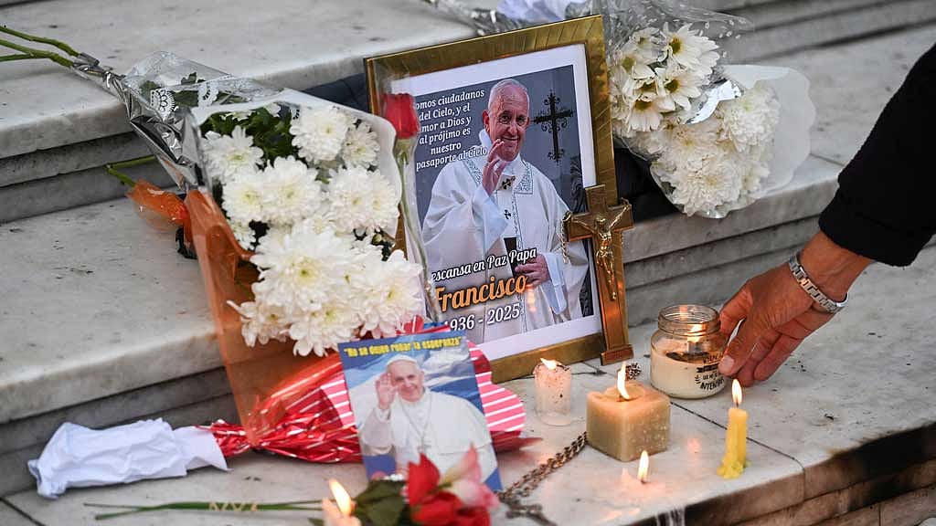 A person leaves a candle in front of a picture of Pope Francis outside the Buenos Aires' Metropolitan Cathedral, following the death of the pontiff, in Buenos Aires, Argentina, April 21, 2025. REUTERS