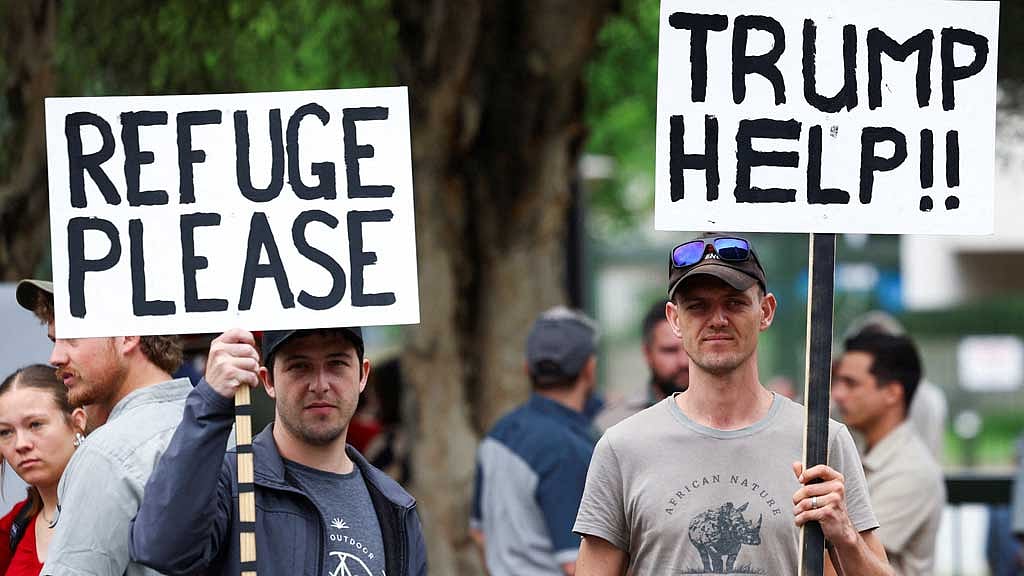 Demonstrators hold placards in support of US President Donald Trump's stance against what he calls racist laws, land expropriation, and farm attacks, outside the American Embassy in Pretoria, South Africa, February 15, 2025. REUTERS