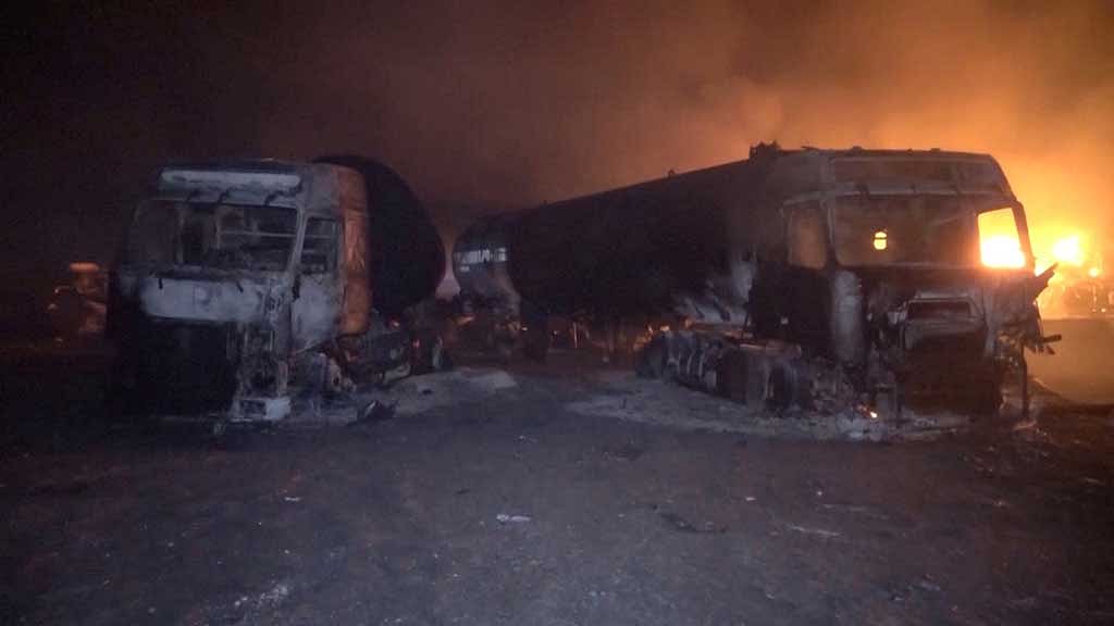 Fire and smoke rise next to charred vehicles following, what Al Masirah TV said, was a US strike on the Ras Isa fuel port, Yemen, in this screengrab from a handout video released on Apr 18, 2025. Al-Masirah TV /Handout via REUTERS