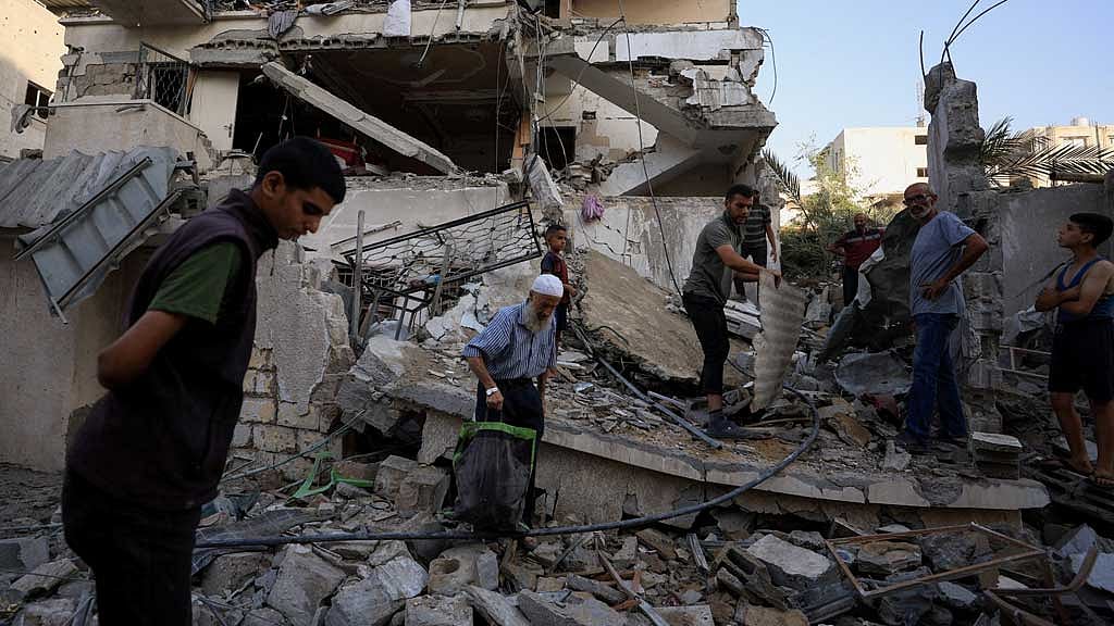 Palestinians inspect the site of an overnight Israeli strike on a house, in Gaza City, August 20, 2025. REUTERS