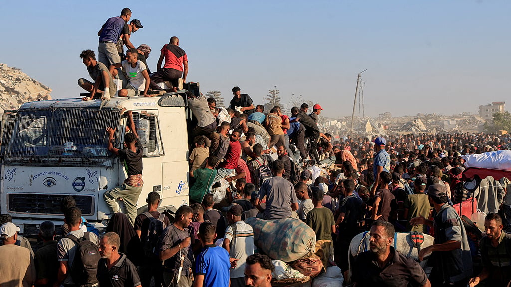Palestinians climb onto a truck as they seek aid supplies in Khan Younis, southern Gaza Strip, Aug 4, 2025. REUTERS/Hatem Khaled