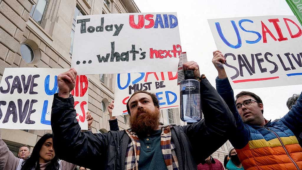 FILE PHOTO: People hold placards outside the USAID building, after billionaire Elon Musk, who is heading US President Donald Trump's drive to shrink the federal government, said work is underway to shut down the US foreign aid agency USAID, in Washington, US, Feb 3, 2025. REUTERS/Kent Nishimura/File Photo