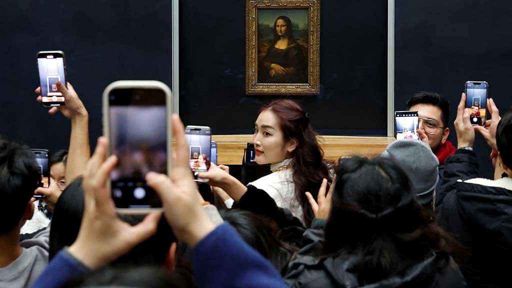 Visitors take pictures of the painting "Mona Lisa" (La Joconde) by Leonardo da Vinci at the Louvre Museum in Paris, France Jan 23, 2025. REUTERS/Gonzalo Fuentes