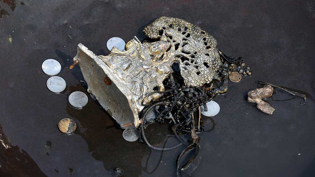 Items collected by people, who go to the river to hunt for coins and other valuables from the waters of river Yamuna, are kept in a container in New Delhi, India, Jun 26, 2025. REUTERS