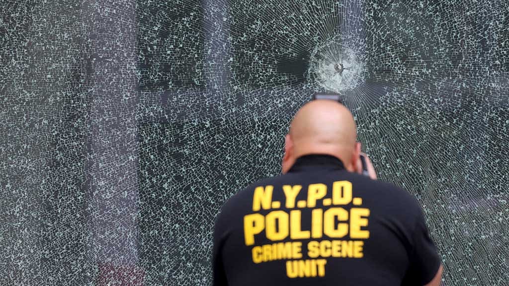 NYPD Crime Scene Unit investigator takes pictures of a bullet hole at the scene of a deadly mass shooting in Manhattan, New York City, US Jul 29, 2025. REUTERS/Kylie Cooper