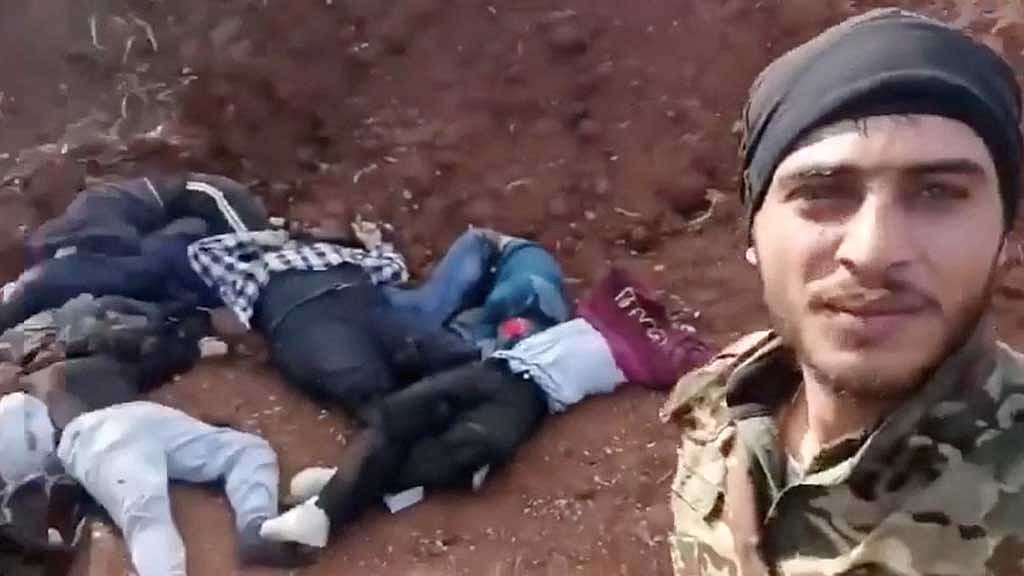 A fighter stands alongside bodies of Alawites in Sonobar, Syria, in this screenshot from a video released on social media, Mar 7, 2025. Reuters verified the location but not the affiliation of the fighter in the video. A Reuters investigation found that from Mar 7-9, 2025, nearly 1,500 Alawites were killed in a government security campaign, including 236 in Sonobar. Social Media/via REUTERS