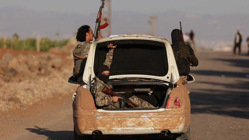 Armed Syrian Bedouin fighters ride in the back of a vehicle, as they launch a new offensive in Syria's Sweida province against Druze fighters, a Bedouin military commander told Reuters on Thursday, despite a truce that had been announced the previous evening to end days of bloody fighting, in Deraa, Syria July 17, 2025. REUTERS