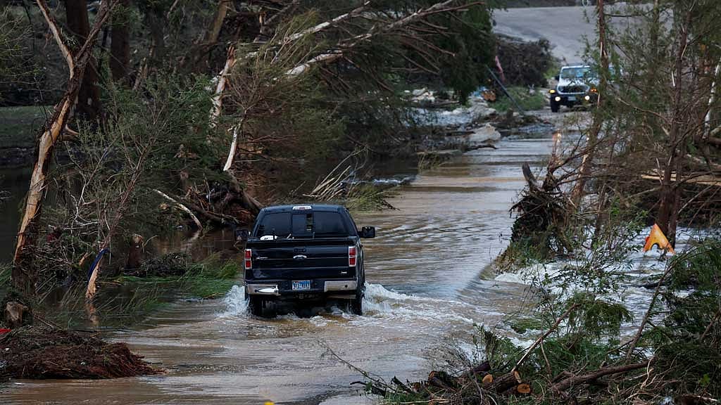 A vehicle rides through a flooded road, following flash flooding, in Hunt, Texas, US Jul 6, 2025. REUTERS   texas-flood-070725-01.JPG