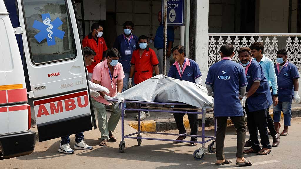 Health workers shift the body of a victim, who died in the plane crash, to a cold storage at a hospital, in the aftermath of an Air India Boeing 787-8 Dreamliner crash during take-off from an airport, in Ahmedabad, India, Jun 13, 2025. REUTERS/Adnan Abidi