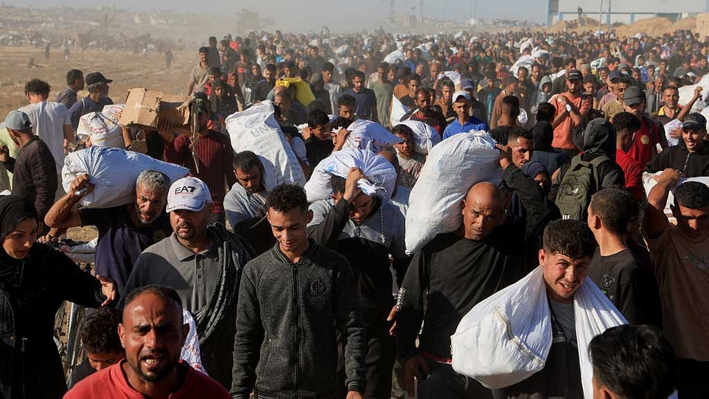 Palestinians carry aid supplies from the US-backed Gaza Humanitarian Foundation, in Khan Younis, in the southern Gaza Strip, May 29, 2025. REUTERS
