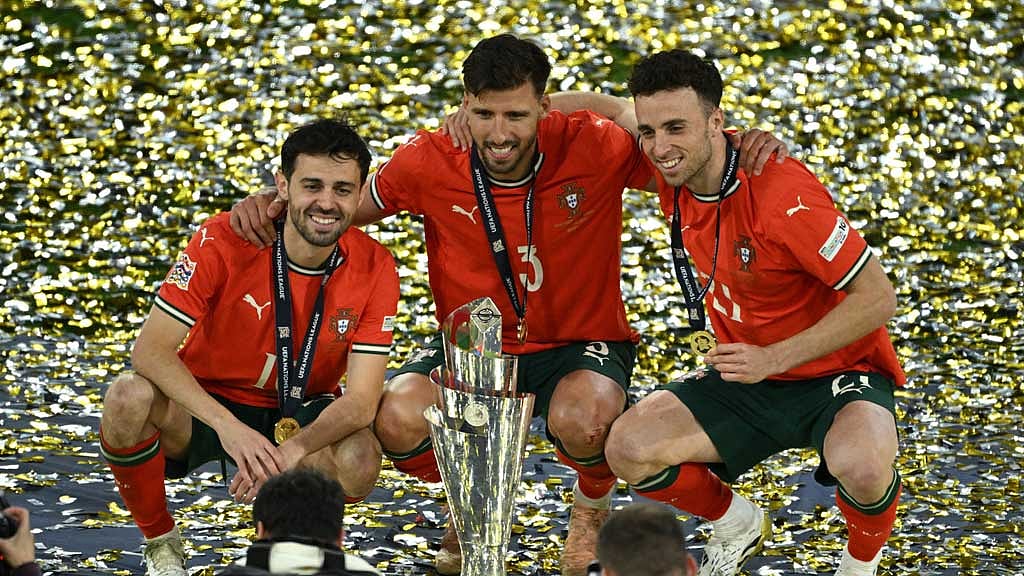  Portugal's Bernardo Silva, Ruben Dias and Diogo Jota celebrate with the trophy after winning the Nations League. REUTERS