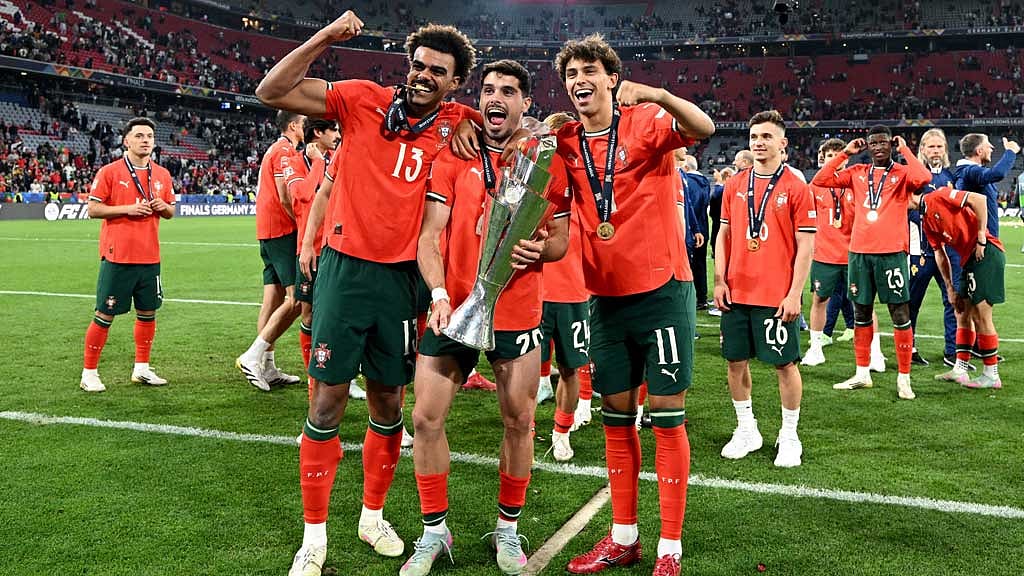 Portugal's Renato Veiga, Pedro Neto and Joao Felix pose for a photo with the trophy as they celebrate winning the Nations League. REUTERS