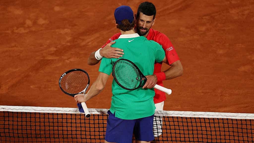 Tennis - French Open - Roland Garros, Paris, France - Jun 6, 2025 Italy's Jannik Sinner hugs Serbia's Novak Djokovic after winning his semi final match REUTERS/Gonzalo Fuentes