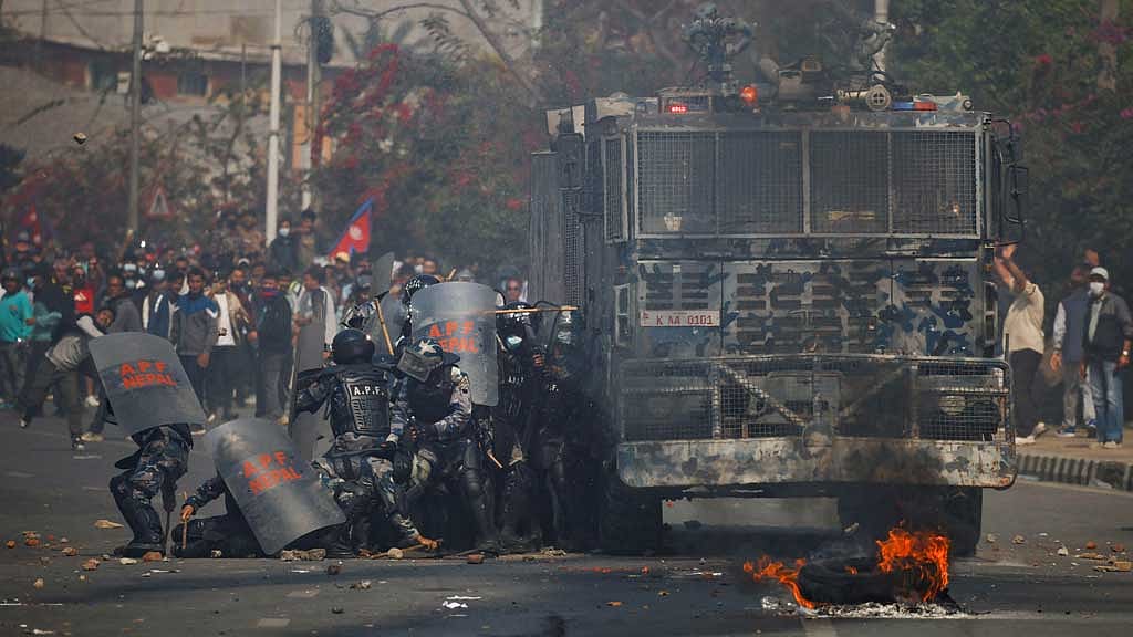 Riot police personnel take cover from stones hurled by pro-monarchist demonstrators during a protest demanding the restoration of Nepal's monarchy, which was abolished in 2008, saying the governments have failed to make any significant changes, in Kathmandu, Nepal, Mar 28, 2025. REUTERS/Navesh Chitrakar