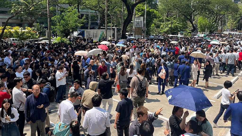 People gather on a street after a strong earthquake struck central Myanmar on Friday, earthquake monitoring services said, which affected Bangkok as well with hundreds of people pouring out of buildings in the Thai capital in panic after the tremors, in Bangkok, Thailand, March 28, 2025. REUTERS