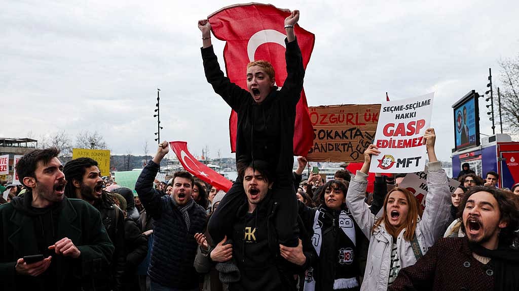 A man carries on his shoulders a person holding a Turkish flag as university students take part in a protest against the detention of Istanbul Mayor Ekrem Imamoglu, in Istanbul, Turkey, Mar 20, 2025. REUTERS/Umit Bektas