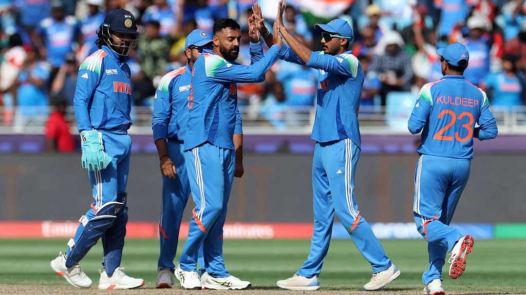 ICC Men's Champions Trophy - Final - India v New Zealand - Dubai International Stadium, Dubai, United Arab Emirates - March 9, 2025 India's Varun Chakravarthy celebrates with teammates after taking the wicket of New Zealand's Glenn Phillips REUTERS/Satish Kumar