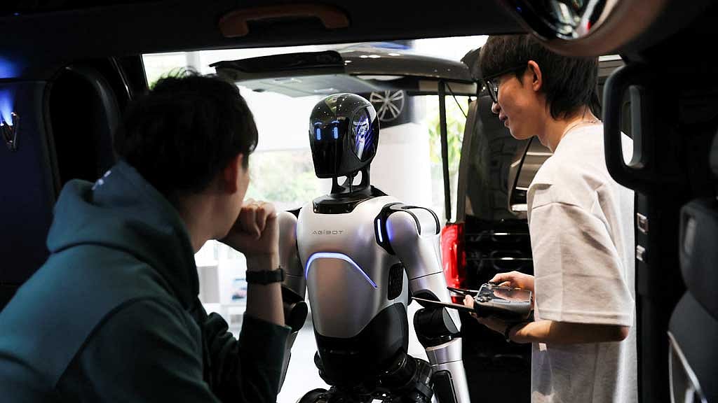 Employees demonstrate an AgiBot humanoid robot at a China Yongda Automobiles Services Holdings Ltd. car dealership, in Shanghai, China, April 8, 2025. REUTERS/Go Nakamura