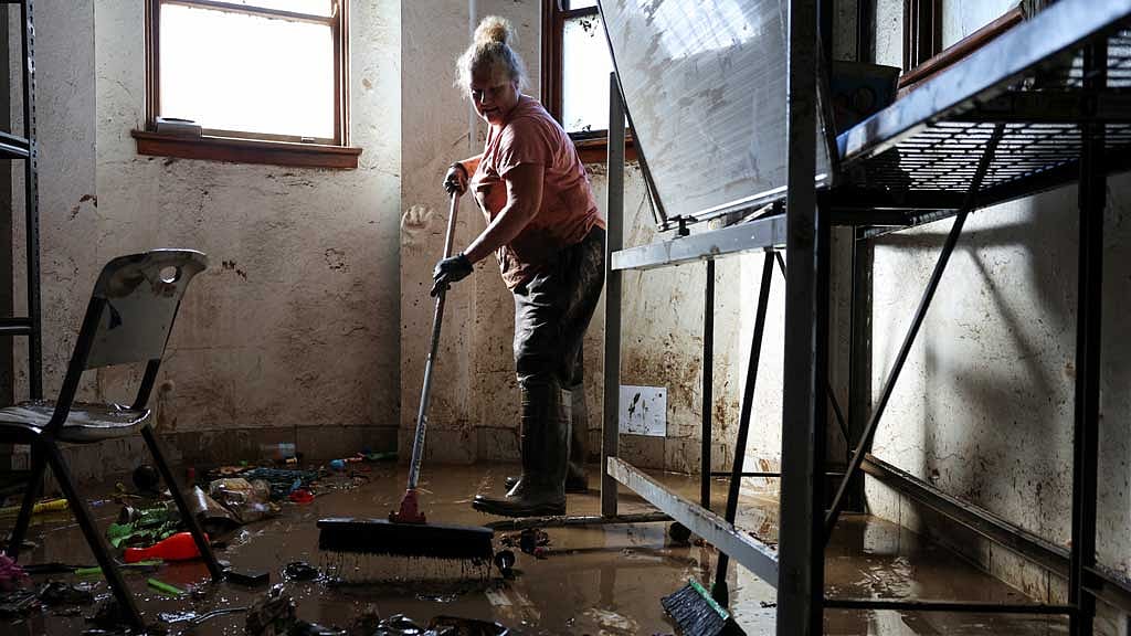 A volunteer cleans up inside a flood affected support centre in Taree, Australia, May 24, 2025. REUTERS