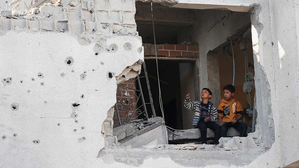 Palestinian boys sit at the site of an Israeli strike on a house, in Jabalia, northern Gaza Strip May 21, 2025. REUTERS