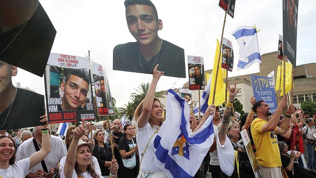 People hold signs with pictures of the Israeli-American hostage, Edan Alexander, who was kidnapped during the deadly Oct 7, 2023, attack, on the day Edan Alexander is expected to be released from captivity by Hamas in Gaza, in Tel Aviv, Israel May 12, 2025. REUTERS/Ronen Zvulun