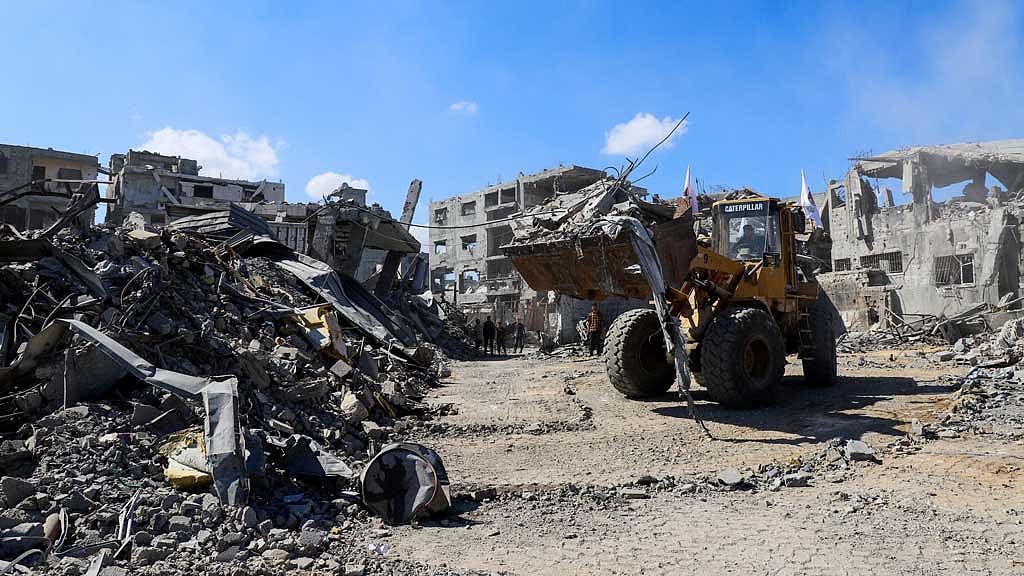 Heavy machinery removes debris from a street, amid a ceasefire between Israel and Hamas, in Gaza City, Oct 14, 2025. REUTERS