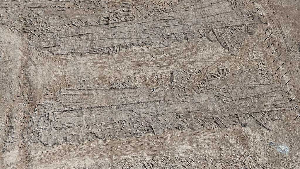 A drone view of imprints, made by bulldozer tracks, on the soil covering a burial trench of a mass grave in the eastern Syrian desert near the town of Dhumair, Feb 27, 2025. A Reuters investigation found that the Assad government secretly trucked thousands of bodies there from an exposed mass grave in the Damascus suburb of Qutayfah from 2019-2021. REUTERS