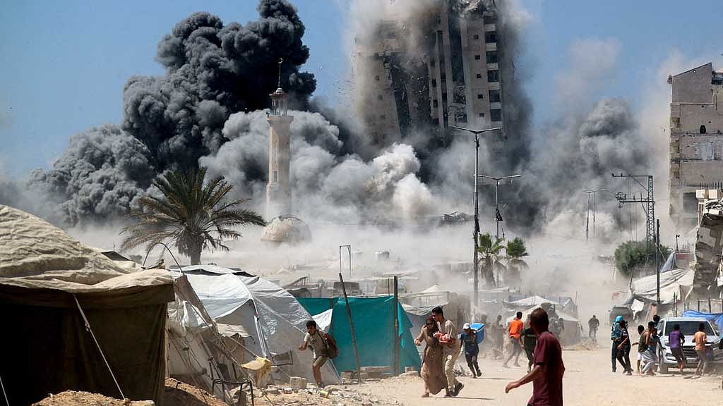 Palestinians run as the 15-storey Mushtaha Tower collapses after being hit by an Israeli air strike, in Gaza City, September 5, 2025. REUTERS