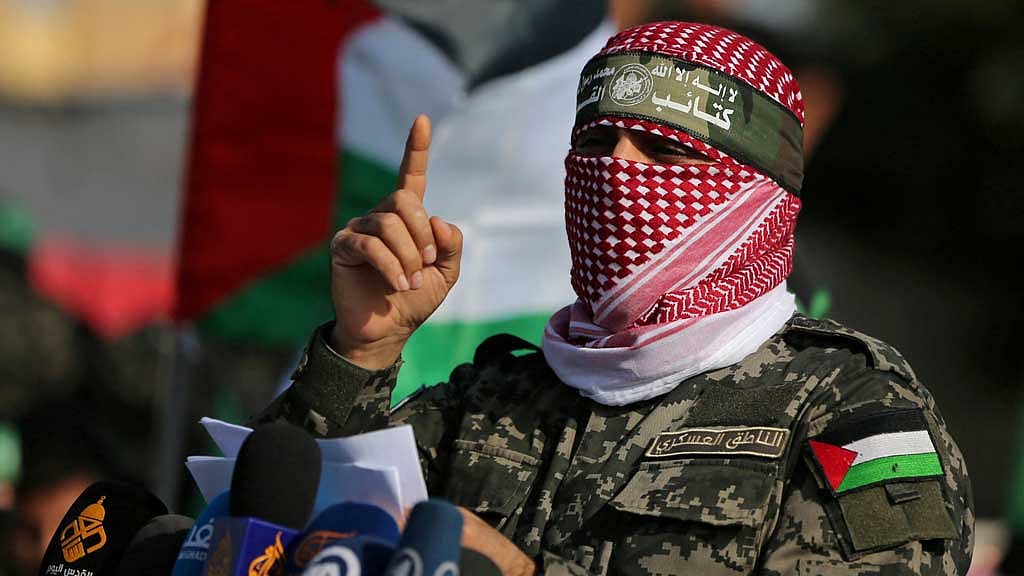 FILE PHOTO: Abu Ubaida, the spokesman of the Izz el-Deen al-Qassam Brigades, gestures as he speaks during an anti-Israel military show in the southern Gaza Strip Nov 11, 2019. REUTERS/Ibraheem Abu Mustafa/File Photo