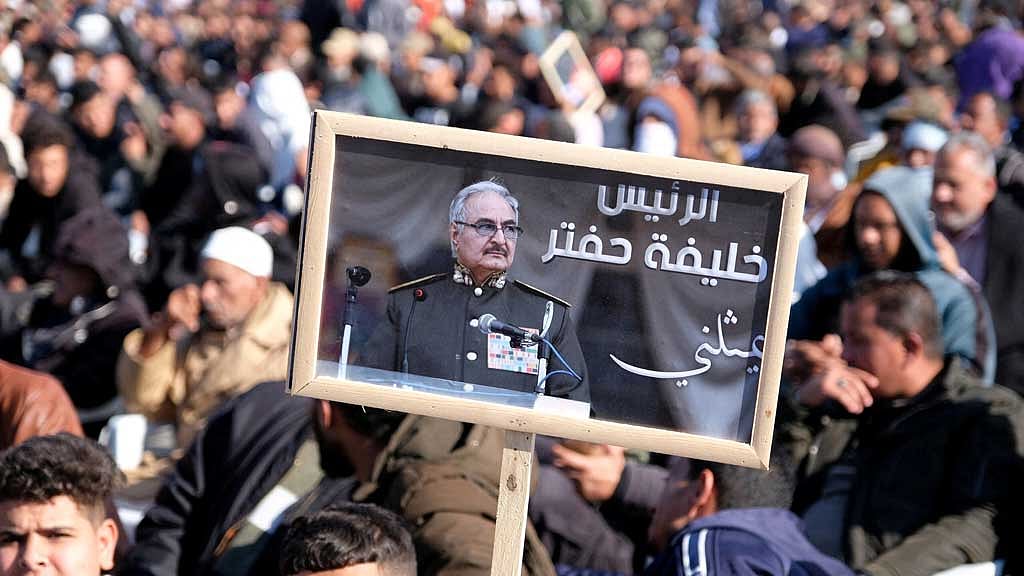  FILE PHOTO: A man holds a picture of commander Khalifa Haftar during Independence Day celebrations in Benghazi, Libya, Dec 24, 2022. REUTERS