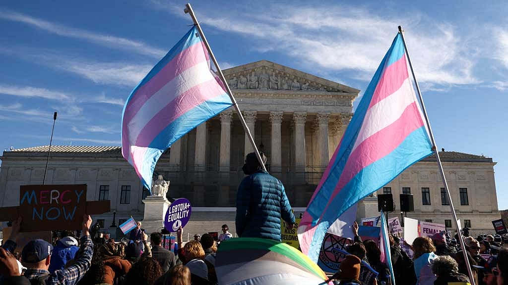 Demonstrators carry a transgender flags outside the US Supreme Court, on the day justices are expected to hear oral arguments in two cases concerning efforts to enforce Republican-backed state laws banning transgender athletes from female sports teams at public schools, in Washington, DC, US, Jan 13, 2026. REUTERS