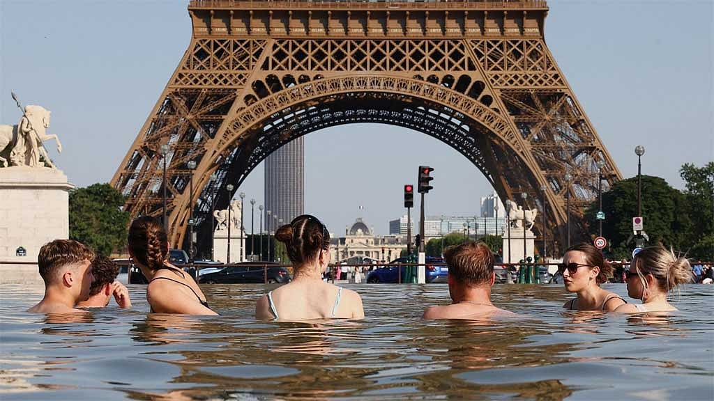 People cool off in the Trocadero Fountain next to the Eiffel Tower in Paris. Photo : Reuters