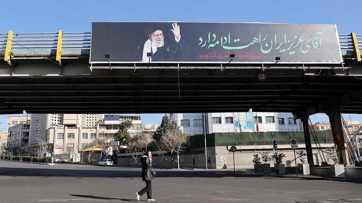 A woman walks past a billboard of Iran's late Supreme Leader Ayatollah Ali Khamenei on a street, after he was killed in Israeli and U.S. strikes on Saturday, in Tehran, Iran, Mar 4, 2026. Majid Asgaripour/WANA (West Asia News Agency) via REUTERS