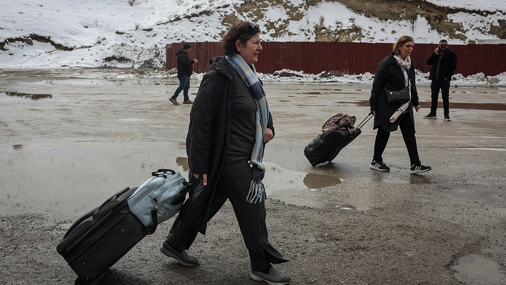 Jalileh Jabari, 63, from Tehran, Iran, walks with a friend after crossing into Turkey, in Van province, Turkey, March 5, 2026. Jabari said she left Tehran because "bombs are falling" and the situation had become unbearable. "If things become good there, if Iran becomes good, I will come back. If there is peace, I will return." REUTERS/Dilara Senkaya 