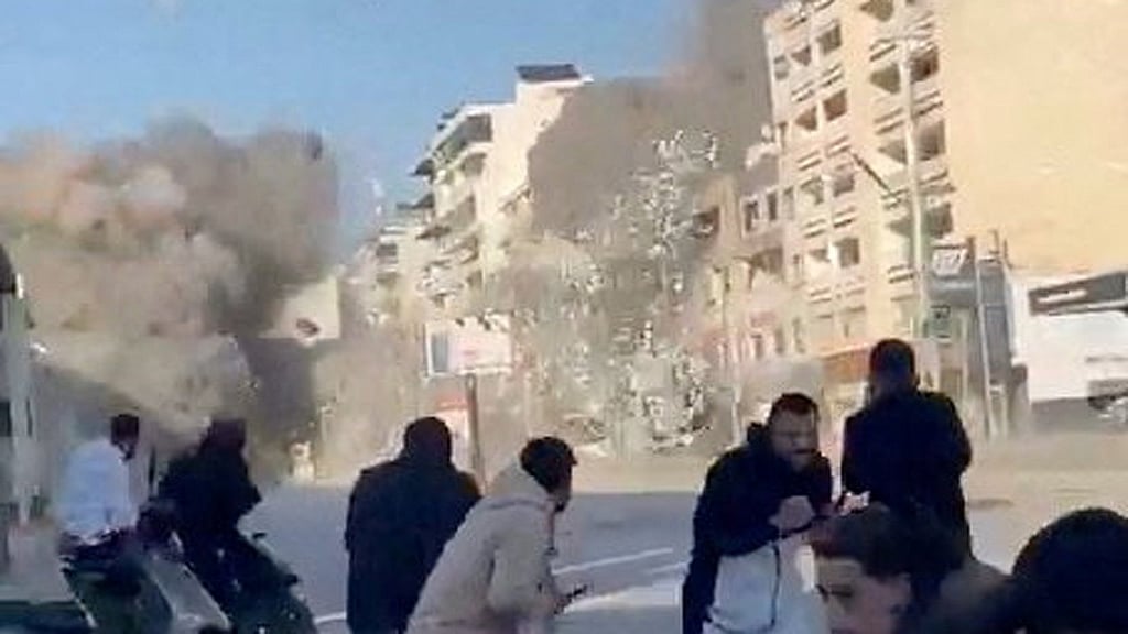 People run as a missile hits a building, following an escalation between Hezbollah and Israel amid the US-Israel conflict with Iran, in Tyre, Lebanon, in this screen grab obtained from a social media video released Mar 2, 2026. Social Media/via REUTERS