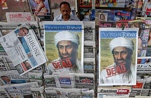 A roadside vendor sells newspapers with headlines about the death of al-Qaeda leader Osama bin Laden, in Lahore, May 3, 2011. Photo: REUTERS 
