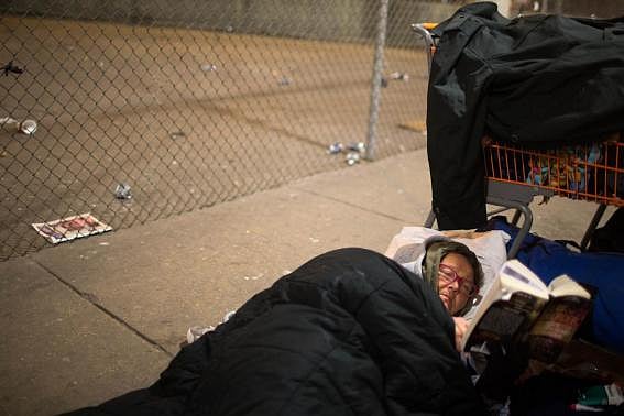 Teresa Sigerson, 51, reads before sleep at overpass she lives under in Chicago. REUTERS/Andrew Nelles. 