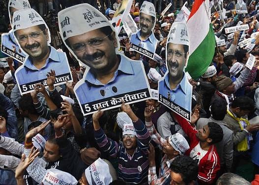 Supporters of AAP hold portraits of AAP chief and its chief ministerial candidate for Delhi, Arvind Kejriwal, during celebrations Feb 10, 2015. REUTERS/Anindito Mukherjee. 