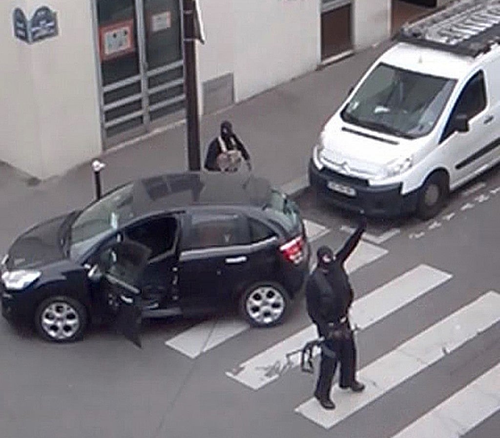 French authorities had removed Said Kouachi and his brother Cherif, the gunmen who attacked the Charlie Hebdo offices in Paris (seen at rear), from the intelligence watch list. Still from video in Paris, January 7, 2015. REUTERS/Reuters TV. 