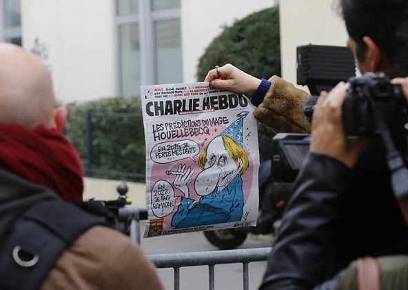 A cameraman shows the front page of Charlie Hebdo which shows a caricature of French author Michel Houellebecq, author of a new book about a fictional Muslim takeover of France, near the weekly's Paris offices after a shooting Jan 7, 2015. REUTERS/Jacky Naegelen. 