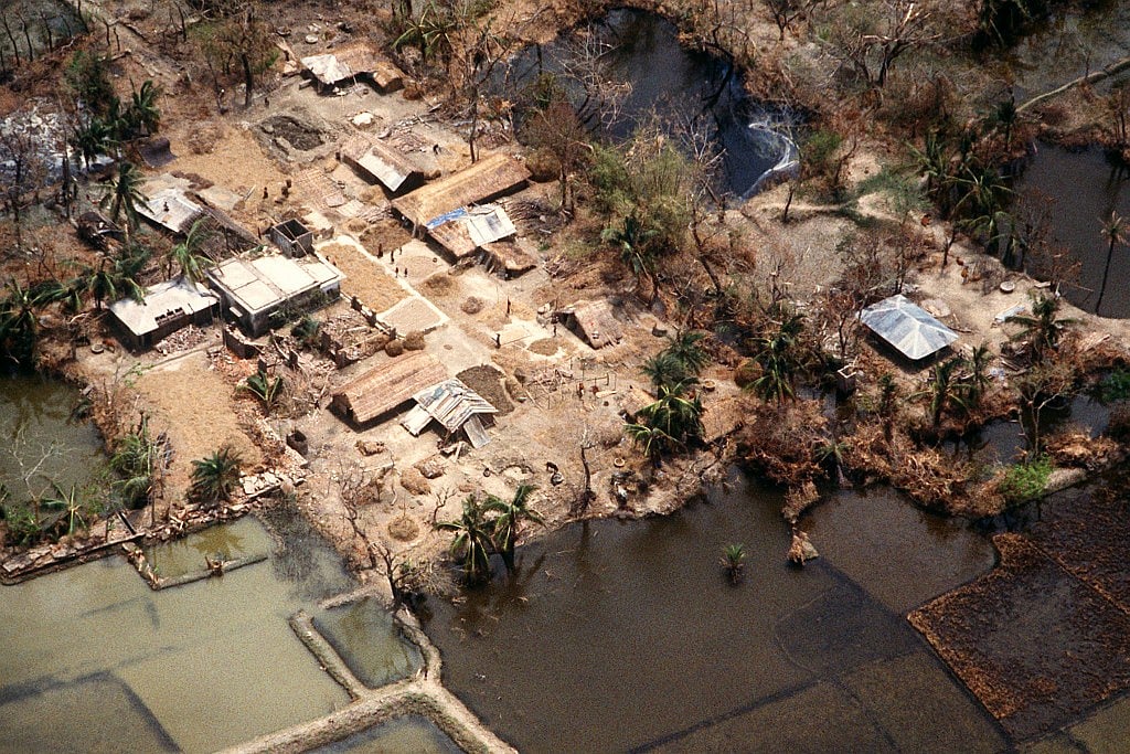 A damaged village surrounded by flooded fields, nearly three weeks after the 1991 Bangladesh cyclone hit the country. (Public Domain) 