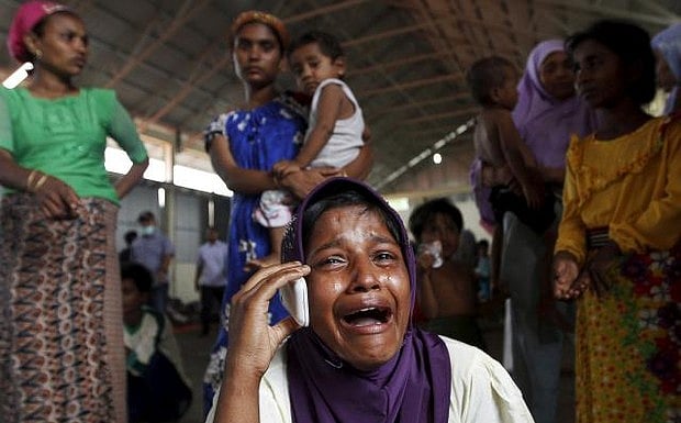 A Rohingya migrant who arrived in Indonesia by boat cries while speaking on a mobile phone with a relative in Malaysia, at a temporary shelter in Kuala Langsa in Indonesia's Aceh Province May 16. Reuters. 