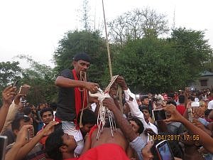 চড়কের দড়ির সাথে সন্ন্যাসীর পিঠে বিদ্ধ হুক বাঁধা হচ্ছে। 