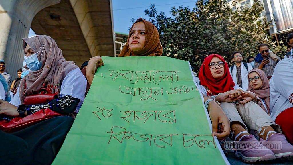 মাসিক ভাতা দ্বিগুণ করার দাবিতে রোববার দুপুরে শাহবাগ মোড়ে প্ল্যাকার্ড হাতে পোস্ট গ্র্যাজুয়েট ট্রেইনি এক চিকিৎসক। ছবি: মাহমুদ জামান অভি