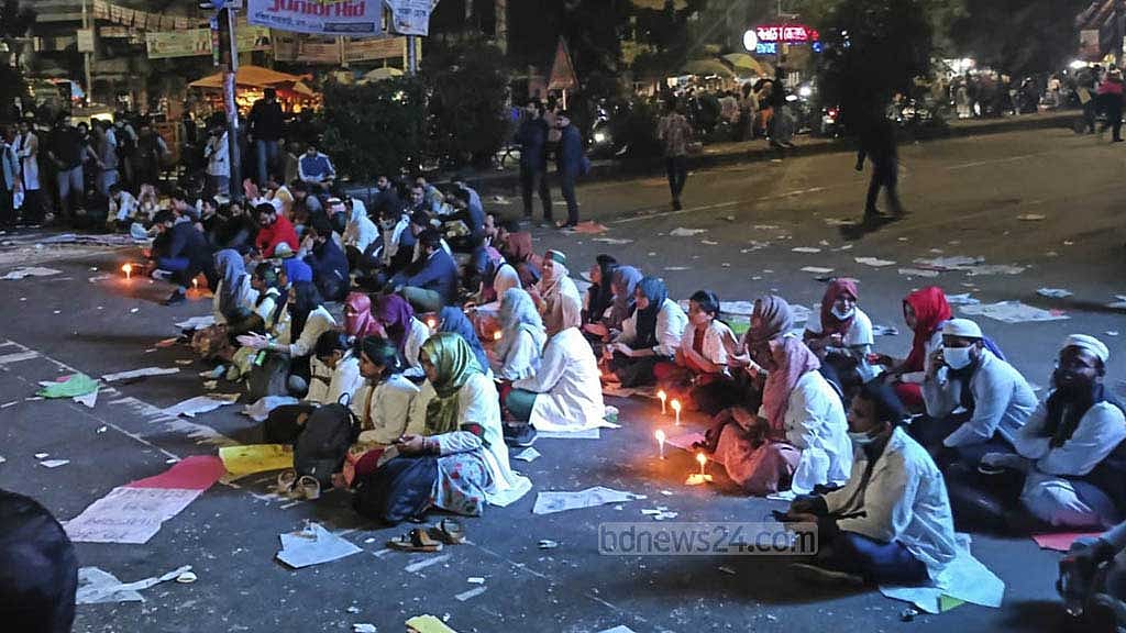 রোববার সন্ধ্যার পরও মোমবাতি জ্বালিয়ে রাজধানীর শাহবাগ মোড়ে বসে থাকেন আন্দোলনকারী চিকিৎসকদের একাংশ।