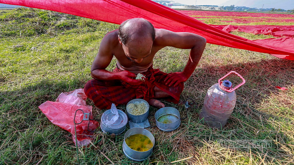 Drying the cloth begins early in the morning, and workers have their breakfast between tasks.