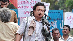 গলায় জুতোর মালা পরে মঞ্চে কী করছেন শিবপ্রসাদ?
